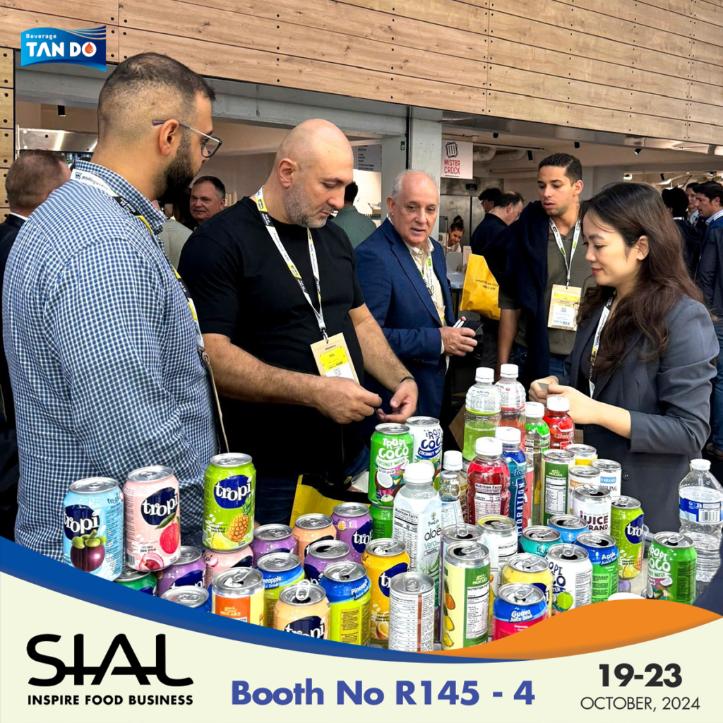 Three people sampling juice drinks in an expo booth