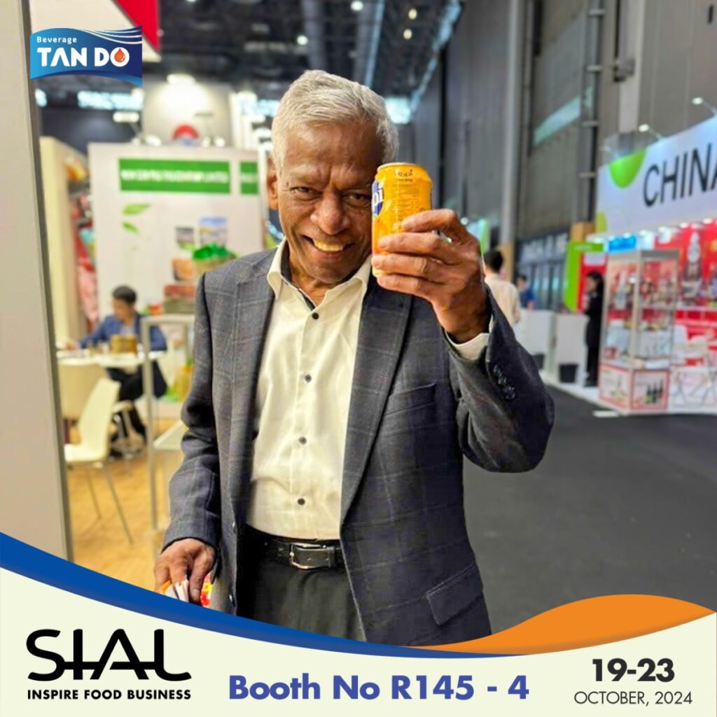 A man smiling while holding a juice drink can